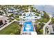 Full aerial view of a wave pool with a yellow slide, palm trees, cabanas and lounge area with seating at 1505 Nassau Point Trl, Kissimmee, FL 34747