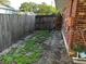 Backyard showing a wooden fence, brick exterior, and grassy patches in the landscape at 1511 Hobson St, Longwood, FL 32750