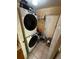 Laundry room with a stacked washer and dryer, tiled floors, and a white door at 1511 Hobson St, Longwood, FL 32750