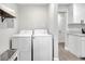 Practical laundry room with washer, dryer, storage shelf, and neutral walls at 1533 Fort Smith Blvd, Deltona, FL 32725