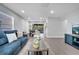 Open living room with blue sofa, wood-look floors, and a view of the dining area and screened-in lanai at 1533 Fort Smith Blvd, Deltona, FL 32725