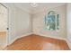 Bright bedroom featuring wood floors, a window with blinds, and white trim at 1542 Islay Ct, Apopka, FL 32712