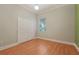 A cozy bedroom with wood floors, a double door closet, and a window with blinds at 1542 Islay Ct, Apopka, FL 32712