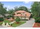 Beautiful two-story home boasting lush landscaping, a red tile roof, and a serene fountain feature at 1542 Islay Ct, Apopka, FL 32712