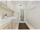 Bright laundry room features white cabinets, washer, dryer and convenient access to the exterior at 1542 Islay Ct, Apopka, FL 32712