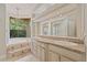 Bright bathroom with double sinks, granite counters, chandelier, and large corner soaking tub with view at 1542 Islay Ct, Apopka, FL 32712