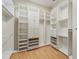 Large walk-in closet with custom built-in shelving and wood floor at 1542 Islay Ct, Apopka, FL 32712