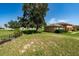 Lush backyard with sprawling lawn, shade trees, and glimpses of surrounding homes at 1543 Club Cir, Lakeshore, FL 33854