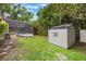 A backyard showing a screened pool, green lawn, and a storage shed on a sunny day at 1874 Royal Majesty Ct, Oviedo, FL 32765
