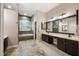 A full bathroom featuring a soaking tub, a vanity with dual sinks, and dark wood cabinets at 1874 Royal Majesty Ct, Oviedo, FL 32765