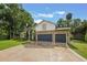 Elegant home with stone accents, three-car garage, and a beautifully landscaped yard, showcasing curb appeal at 1874 Royal Majesty Ct, Oviedo, FL 32765