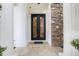 Close-up of a beautiful ornate wrought iron front door with stone surround at 1874 Royal Majesty Ct, Oviedo, FL 32765