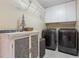 Laundry room with modern appliances, storage cabinets, and decorative accents at 1874 Royal Majesty Ct, Oviedo, FL 32765