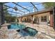 Inviting screened-in pool and spa area with stone decking and ample seating at 1874 Royal Majesty Ct, Oviedo, FL 32765
