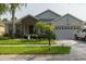 Charming single-story home featuring a stone facade, well-manicured lawn, and attached two-car garage at 2237 Osprey Woods Cir, Orlando, FL 32820