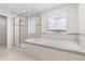 Elegant bathroom featuring a glass shower and a large soaking tub under a window at 2431 Tudor Rose Dr, Sanford, FL 32773