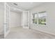 Versatile room with neutral walls and carpet, featuring french doors and a window for ample light, adaptable as bedroom or office at 2431 Tudor Rose Dr, Sanford, FL 32773
