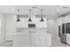 Modern kitchen features white cabinetry, a marble backsplash, stainless appliances, and a center island at 2431 Tudor Rose Dr, Sanford, FL 32773