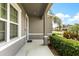 View of the front porch, showing the home's exterior, landscaping, and neighborhood street beyond at 2431 Tudor Rose Dr, Sanford, FL 32773