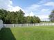Large, fenced backyard with mature trees beyond the property line at 2451 Strandhill St, Orlando, FL 32824