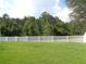Fenced yard with well-manicured lawn and mature trees at 2451 Strandhill St, Orlando, FL 32824