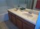 A bathroom features a double vanity with brown cabinetry and white countertops, reflecting ample light from above at 2451 Strandhill St, Orlando, FL 32824