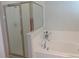 A bright bathroom features a tiled tub and a glass-enclosed shower for a luxurious bathing experience at 2451 Strandhill St, Orlando, FL 32824