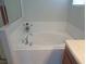 An elegant white bathtub is surrounded by white tiling and enhanced by chrome fixtures for a pristine bathing experience at 2451 Strandhill St, Orlando, FL 32824