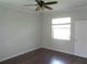 Bedroom with hardwood floors, ceiling fan, and large window providing natural light at 2451 Strandhill St, Orlando, FL 32824