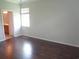 Light-filled bedroom with hardwood flooring and a window, adjacent to an ensuite bathroom at 2451 Strandhill St, Orlando, FL 32824