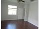 A bedroom featuring beautiful hardwood flooring, a ceiling fan, and a bright window at 2451 Strandhill St, Orlando, FL 32824