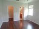Bedroom featuring hardwood floors, window, and doorways leading to a closet and bathroom at 2451 Strandhill St, Orlando, FL 32824