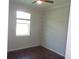 This is a bedroom with a window and dark floors. A ceiling fan is in the room at 2451 Strandhill St, Orlando, FL 32824