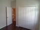 A bedroom with a closet with doors, an open entry, and hard wood floors at 2451 Strandhill St, Orlando, FL 32824