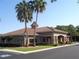 View of a community building with well-manicured lawn and palm trees at 2451 Strandhill St, Orlando, FL 32824