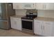 Kitchen with stainless steel range, white cabinets and granite countertops at 2451 Strandhill St, Orlando, FL 32824