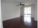 Open living area with dark hardwood flooring, ceiling fan, and access to the outdoor patio at 2451 Strandhill St, Orlando, FL 32824