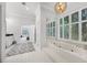 Bright bathroom with a large tub under a window, and a doorway to the main bedroom at 2487 River Tree Cir, Sanford, FL 32771