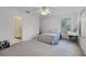 Bright bedroom featuring a ceiling fan, plantation shutters, and an adjacent bathroom entry at 2487 River Tree Cir, Sanford, FL 32771