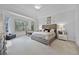 A serene main bedroom with tray ceilings, lots of light from the large windows, and a sitting area at 2487 River Tree Cir, Sanford, FL 32771
