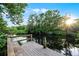Wooden dock on the pond with a ladder provides direct access to the water, surrounded by lush trees at 2487 River Tree Cir, Sanford, FL 32771