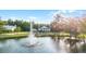 Picturesque home overlooks a serene pond with fountain, framed by mature trees and lush landscaping at 2487 River Tree Cir, Sanford, FL 32771
