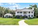 Charming white home with classic columns, black shutters, and a gracefully curved walkway at 2487 River Tree Cir, Sanford, FL 32771