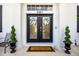 Elegant double front doors with glass inserts, wreaths, welcome mat and potted topiaries provide a warm entrance at 2487 River Tree Cir, Sanford, FL 32771