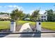 Inviting entryway with stone pillars, mature trees, and lush landscaping leading to a distinguished property at 2487 River Tree Cir, Sanford, FL 32771