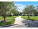 Well-manicured front yard featuring a long driveway, lush green grass, and mature trees creating a grand entrance at 2487 River Tree Cir, Sanford, FL 32771