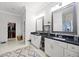 Bright bathroom featuring dual vanities with black countertops, and a walk-in closet at 2487 River Tree Cir, Sanford, FL 32771