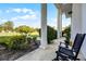 Relaxing covered patio with white columns offers peaceful views of the manicured lawn and landscaping at 2487 River Tree Cir, Sanford, FL 32771