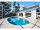 The screened pool area offers a brick patio, with an oval pool and views of the home and manicured backyard at 2487 River Tree Cir, Sanford, FL 32771