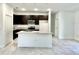 Modern kitchen featuring dark cabinets, granite countertops, and an island with a sink at 2645 Sw 155Th Ln, Ocala, FL 34473